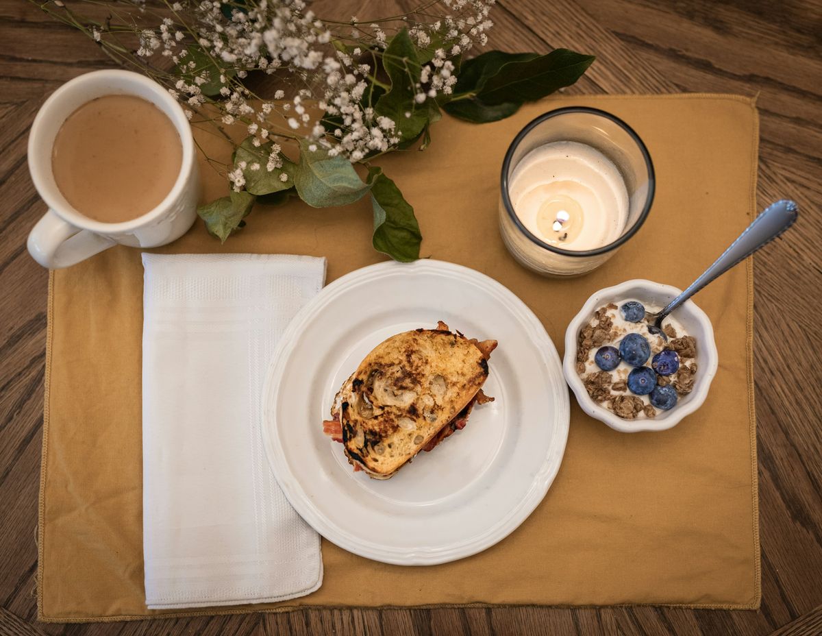 Breakfast table seen from above with coffee, bread and fruit