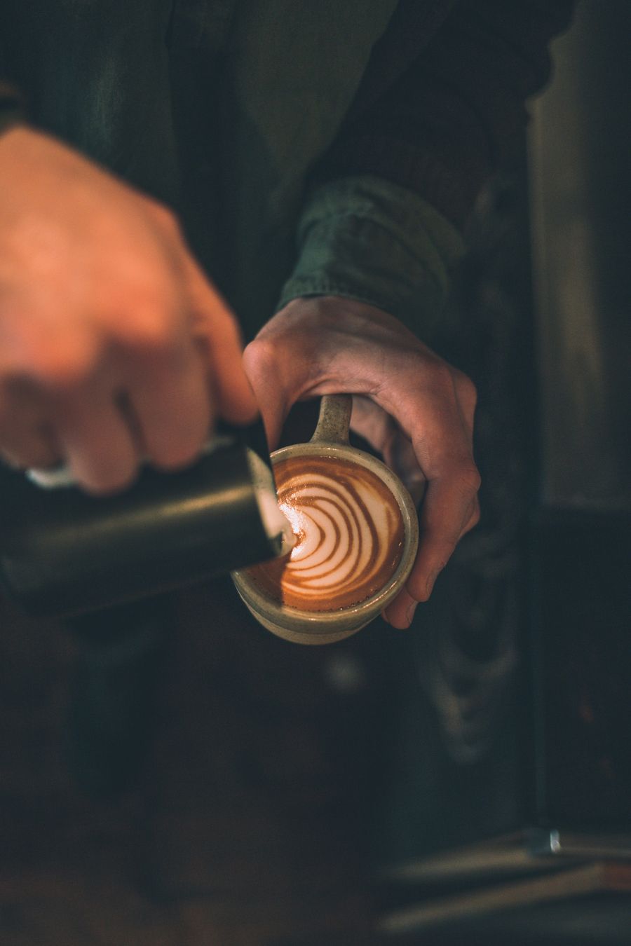 Milk being poured into a cup of coffee